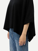 Women's Black Cashmere  Knitted Poncho worn by model, side view, on white background