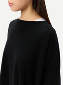 Women's Black Cashmere  Knitted Poncho worn by model, side view, on white background