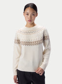 A model wearing a cream-colored knit sweater with a brown and beige Fair Isle pattern across the yoke and shoulders, paired with black pants, against a light gray studio background.#color_off-white