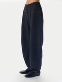 A person wearing dark navy wide-leg knit pants and matching dark loafers, shown from the waist down against a plain light gray studio background.