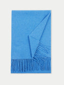 a blue colored fringed scarf on a light gray background