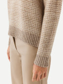 A woman wearing a beige and brown striped sweater with round neckline. #color_soft-white