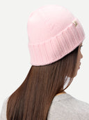 back view of a person wearing a pink knit beanie on a white background