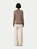 Woman wearing a brown cashmere sweater against a white background #color_taupe