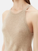 Woman wearing a beige sleeveless cashmere top against a white background. #color_warm-grey