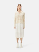 A woman wearing a beige organic color mixed pattern cashmere polo neck sweater with a V-neckline and long sleeves. #color_off-white