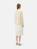A woman wearing a beige organic color mixed pattern cashmere polo neck sweater with a V-neckline and long sleeves. #color_off-white