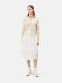 A woman wearing a beige organic color mixed pattern cashmere polo neck sweater with a V-neckline and long sleeves. #color_off-white
