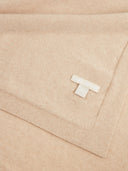 A close-up of a soft, folded beige knit fabric with a visible white woven brand tag reading 'COBI ORGANIC'.