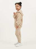 Child wearing a beige cashmere tracksuit on a white background #color_beige