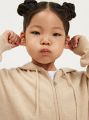 Child wearing a beige cashmere tracksuit on a white background #color_beige