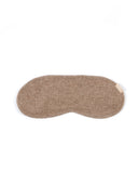 A single sleep mask in a soft, textured taupe-brown fabric, laid flat against a solid white background.