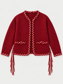 A red cropped cardigan sweater with braided trim and fringe details, displayed flat against a light gray background.