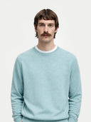 Men's Blue Haze Cashmere Crewneck Sweater worn by model, detail view on white background 