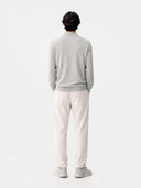 Person wearing a gray sweater and white pants standing against a white background. #color_urban-gray