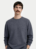 Man wearing a gray sweater against a white background