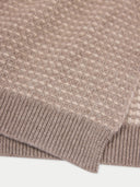 Close-up of a textured brown fabric with a white background.