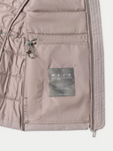 Close-up of a beige jacket with a brand label on a white background