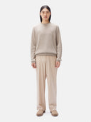 A man wearing a beige crewneck cashmere sweater and matching trousers. #color_taupe