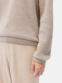 A man wearing a beige crewneck cashmere sweater and matching trousers. #color_taupe