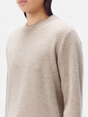 A man wearing a beige crewneck cashmere sweater and matching trousers. #color_taupe