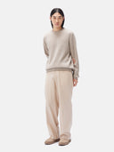 A man wearing a beige crewneck cashmere sweater and matching trousers. #color_taupe