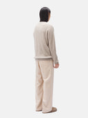 A man wearing a beige crewneck cashmere sweater and matching trousers. #color_taupe