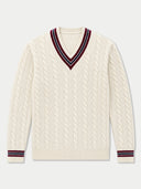 An off-white cable-knit V-neck sweater with navy and red striped trim on the collar and cuffs, displayed flat against a light gray background.