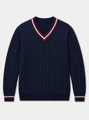 A navy blue cable-knit V-neck sweater with red and white striped trim on the collar and cuffs, shown flat against a light gray background.