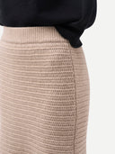 A taupe knit cashmere sweater skirt with a textured open-knit pattern, shown flat against a light gray background. #color_dusty-beige