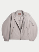 Flat lay of the CashmereTech bomber jacket in smoke gray, opened to show the quilted inner jacket layered inside.