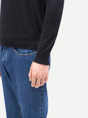 Men Classic Polo Shirt with Long Sleeve Black worn by model, side view on white background