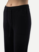 Black wide-leg trousers with an elastic drawstring waistband, displayed flat against a light gray background.