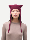 Person wearing a purple knit hat with cat ears on a white background. #color_deep-wine