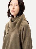 Women wearing an Aloe green triangular cashmere scarf against a plain white background