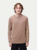 A male model wearing a beige long-sleeved crewneck cashmere sweater.#color_taupe-brown