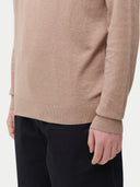 A male model wearing a beige long-sleeved crewneck cashmere sweater.#color_taupe-brown