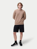 A male model wearing a beige long-sleeved crewneck cashmere sweater.#color_taupe-brown
