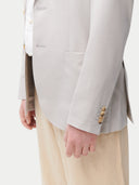 Man wearing a light gray blazer over a white shirt with beige pants on a white background. #color_light-taupe