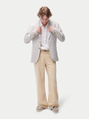 Man wearing a light gray cashmere blazer, white shirt, and beige pants on a white background. #color_light-taupe