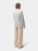 Person wearing a light gray cashmere blazer and beige pants on a white background. #color_light-taupe