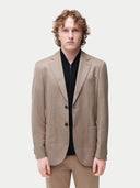Men's Taupe single-breasted cashmere blazer worn by model detail view on backround