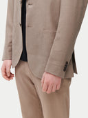 Men's Taupe single-breasted cashmere blazer worn by model detail view on backround