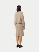 A woman wearing a beige long-sleeved cropped t-neck sweater and a matching skirt. #color_duty-beige