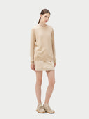 Women's Beige Cashmere Basic Crew Neck Sweater worn by model, side view on white background
