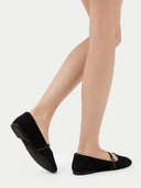 Pair of black flat shoes with a strap on a light gray background #color_black