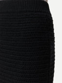 Black ribbed knit pencil cashmere skirt on a light gray background #color_black
