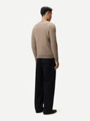 Man wearing a beige checkered cashmere sweater and black pants on a white background. #color_taupe