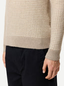 Beige textured cashmere sweater worn by a person on a white background. #color_dusty-beige