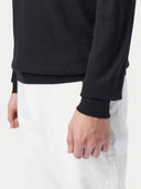 Black long-sleeve cashmere polo shirt on a light gray background. #color_black